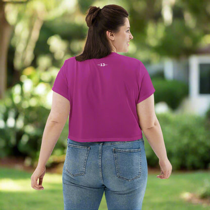 Back view of a woman wearing Magenta Muse Crop Tee in the backyard