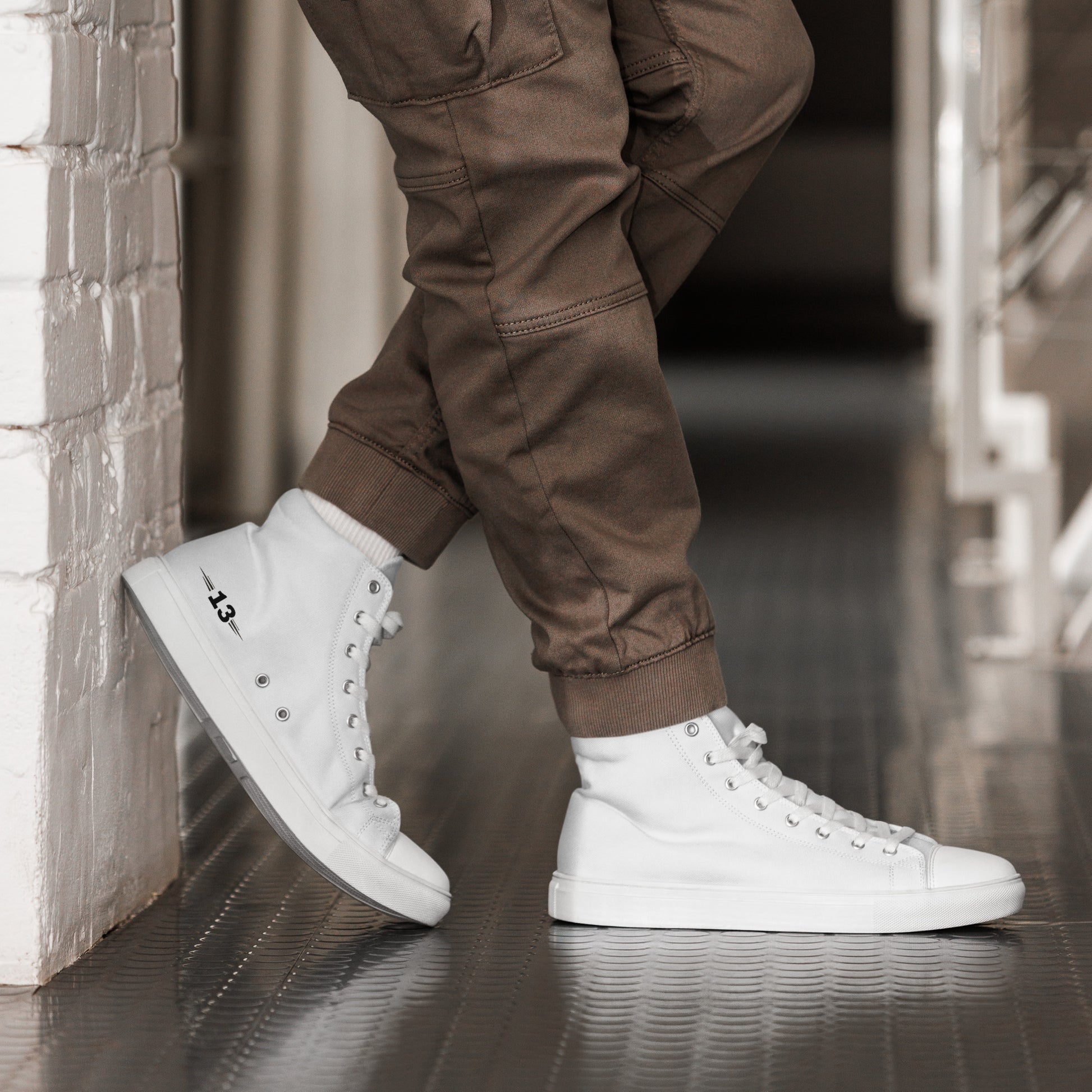 man standing against a wall in Men's High Top Canvas Sneakers with white sole