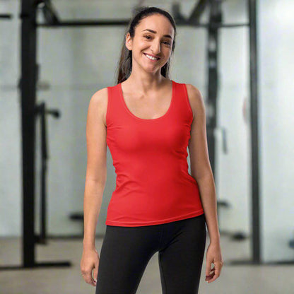 Woman wearing the Radiance Tank in Fiery Red, posing confidently in a gym setting.